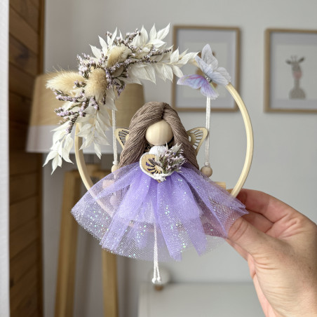 Poupée-papillon dans une couronne de fleurs séchées